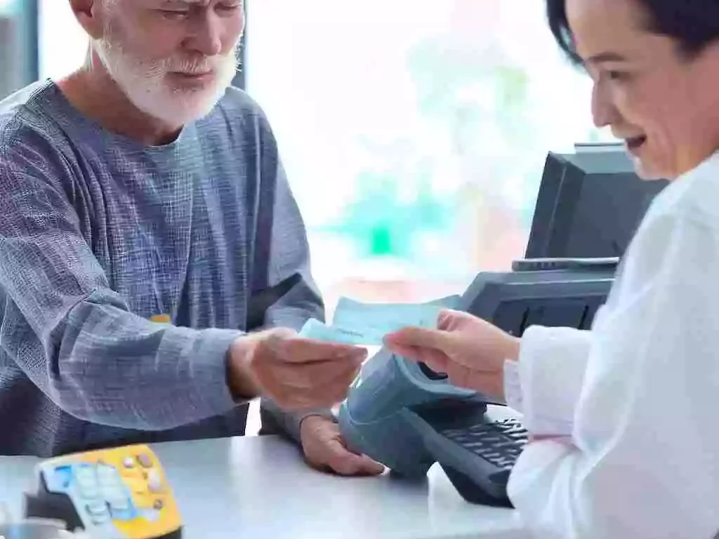 senior citizen paying minimum co payment to cashier while in hospital